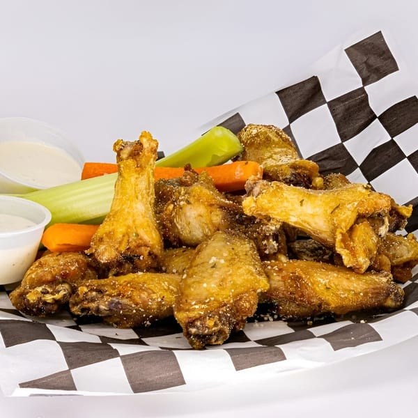 Golden-brown chicken wings with celery, carrots, and two dipping sauces on checkered paper from Life's Good Bar & Grill.
